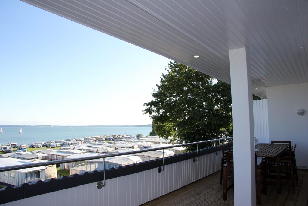 Ferienwohnung Südstrand I, überdachter Balkon mit Esstisch und Blick auf die Ostsee
